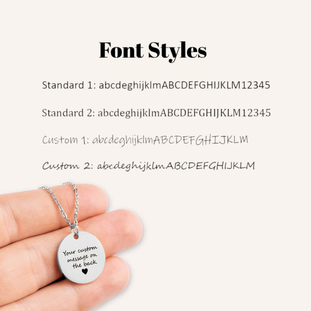 Silver necklace with a round pendant displaying customizable text on a white background with font styles options.