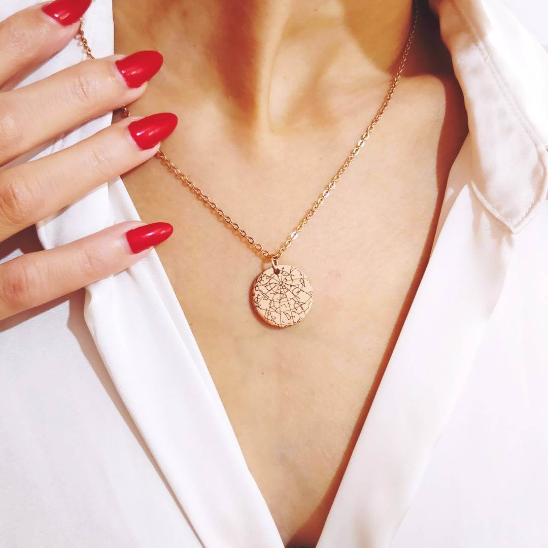 A model wearing an elegant 18k rose gold plated star map necklace in premium engraving.