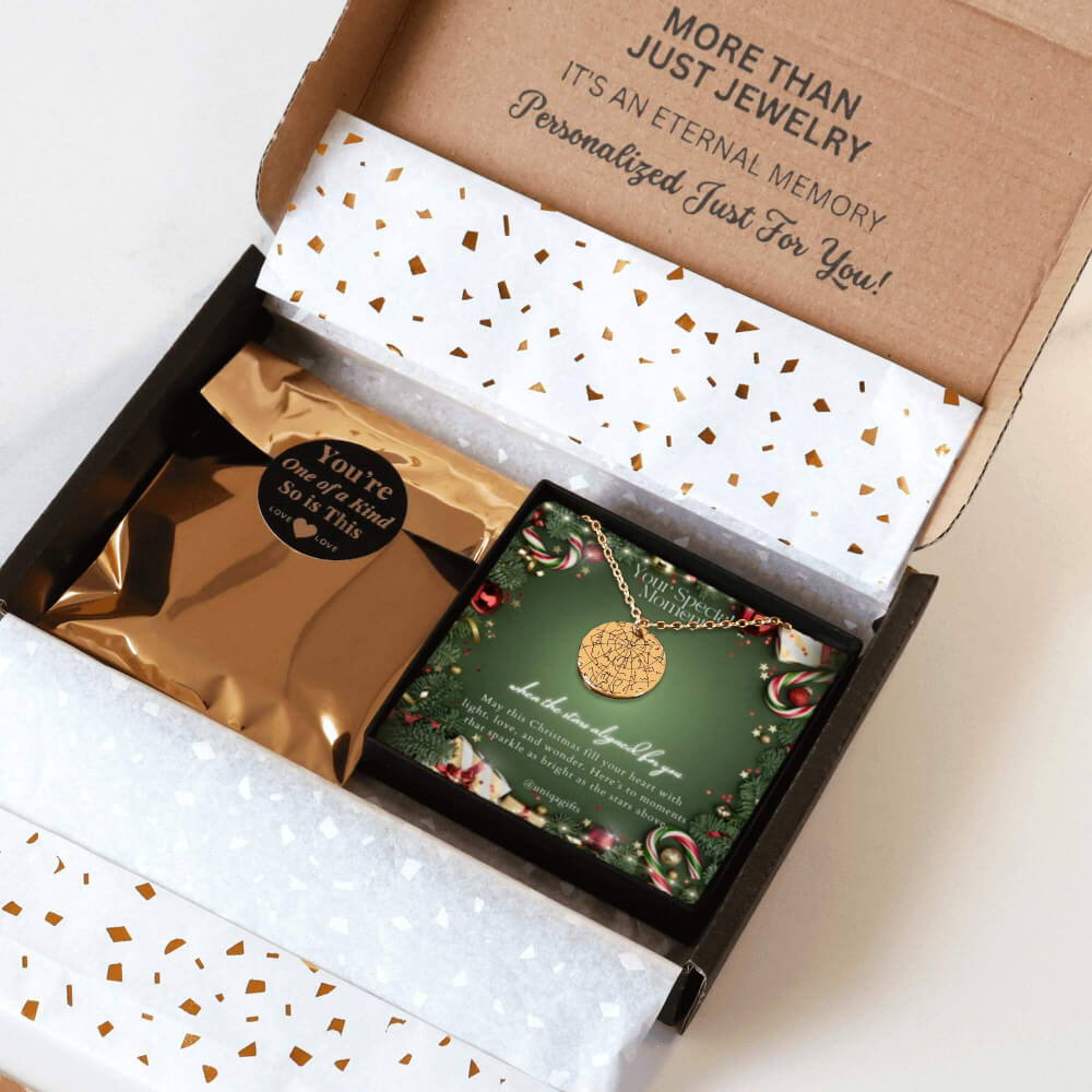 Personalized gold necklace with a coin pendant engraved in custom star map, packaging in a gift box with a festive greeting card in a Christmas design and gold confetti paper, held by hands against a neutral background.