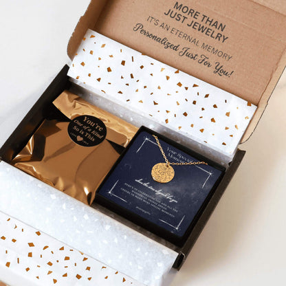 Personalized gold necklace with a coin pendant engraved in a custom star map, packaging in a gift box with a festive greeting card for any occasion, and gold confetti paper, held by hands against a neutral background.